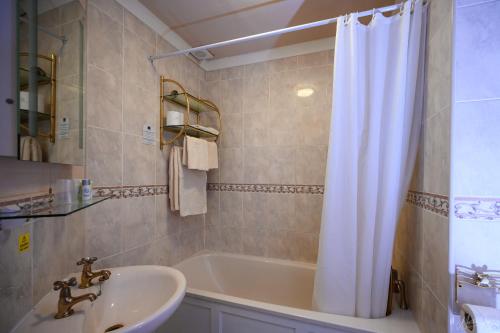 韦姆Old Rectory的浴室配有水槽、浴缸和淋浴帘