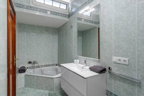 圣巴托洛梅Villa Marlenghi with Private Pool的一间带水槽、浴缸和镜子的浴室