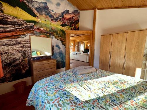 南塞尔尼Reeds Lodge, Lake Pochard的卧室配有一张床,墙上挂有绘画作品