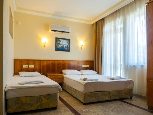 贝尔迪比Tal Beach Hotel的酒店客房设有两张床和窗户。