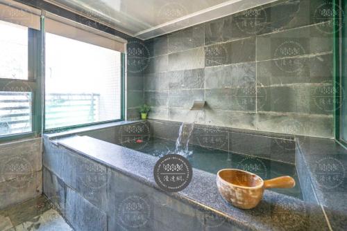 礁溪泉泉溫泉民宿的一间带浴缸及碗在柜台的浴室