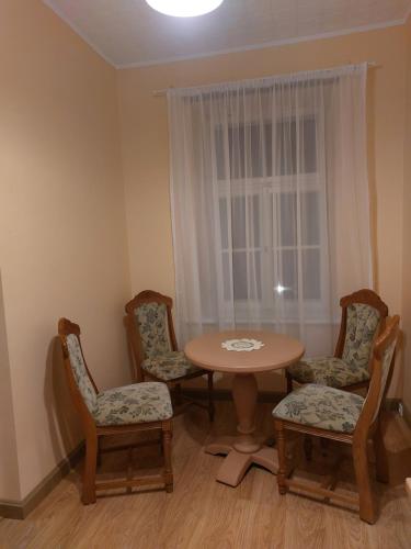 坎达瓦Pils ielas apartamenti的客房设有桌椅和窗户。