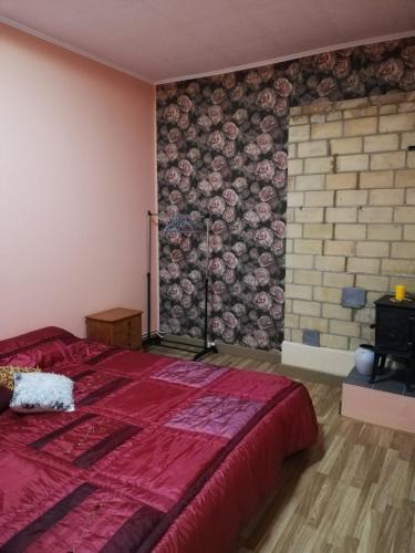 坎达瓦Pils ielas apartamenti的一间卧室设有红色的床和砖墙
