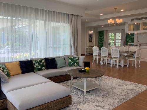 华欣Seapine Beach Golf and Resort Hua Hin的客厅配有沙发和桌子