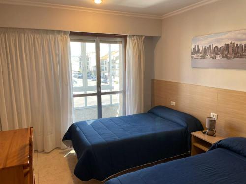 奥伦塞HOSTAL CID的酒店客房设有两张床和窗户。