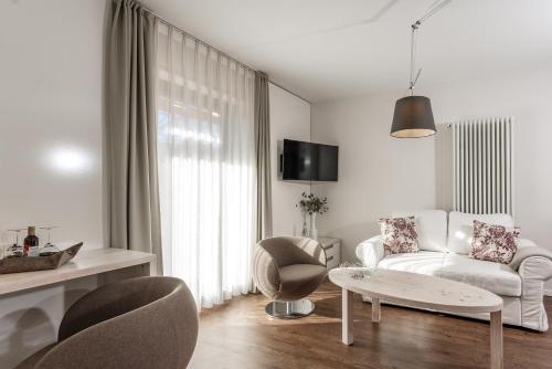 巴特维塞Hotel Villa Lago Garni的白色的客厅配有白色的沙发和椅子