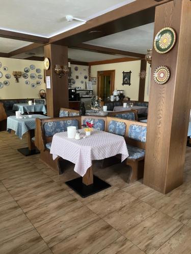 德布里阿赫豪斯卡尔顿酒店的餐厅配有桌椅和桌椅