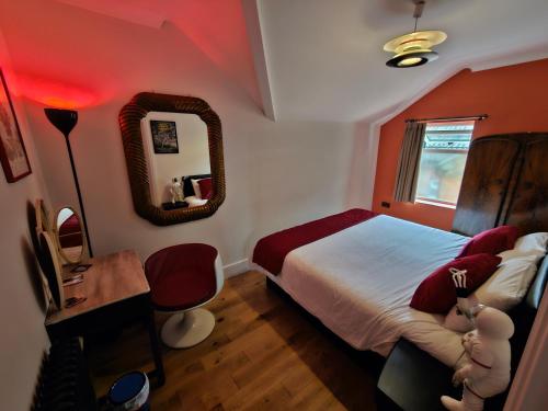 朴次茅斯Southsea Royale James Bond 3 bed Cool Penthouse, seafront parking的一间卧室配有一张床、一张书桌和一面镜子
