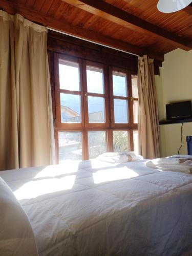 利亚内斯EL COLLAU的卧室配有一张大白色床和窗户