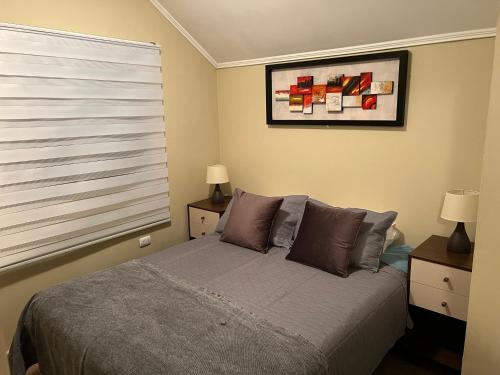 奇廉Apart Hotel Chillan - Home Cozy - Empresas - Factura - Aire acondicionado的一间卧室配有一张带窗户和两盏灯的床。