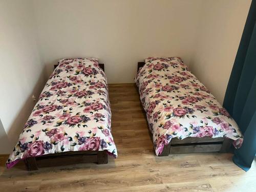 亚赫兰卡Pensjonat Jachranka的一间卧室配有两张鲜花床。