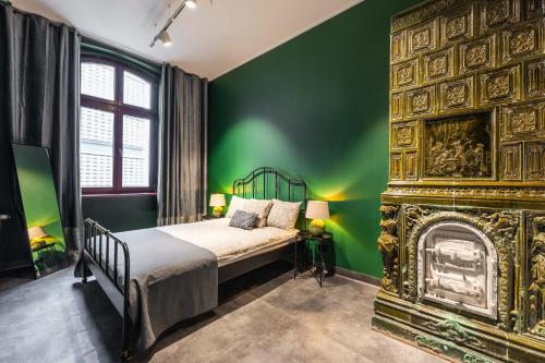 卡托维兹LivingRoom 2 z wanną z hydromasażem的绿色卧室设有1张床和1个壁炉