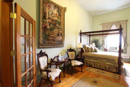 Merrickville鲍德驰酒店的卧室配有一张床和一张桌子及椅子