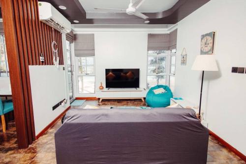 胡鲁马累Charming Beachfront 2BR Apartment in Hulhumale’的客厅配有大床和电视