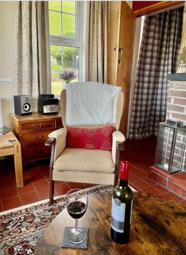 拉尼德洛伊斯PantYCae的客厅配有椅子和一瓶葡萄酒