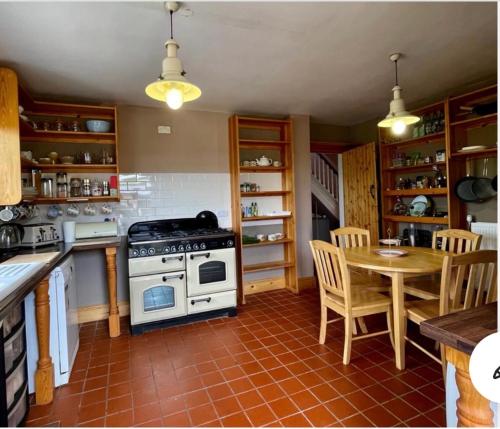 拉尼德洛伊斯PantYCae的厨房配有炉灶和桌椅