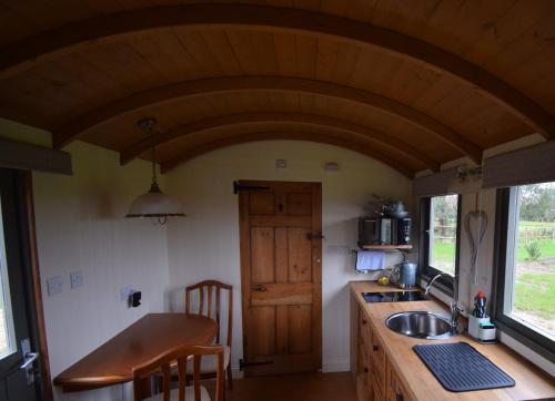 查尔德Forton House Shepherd's Huts的一个带水槽和木制天花板的厨房