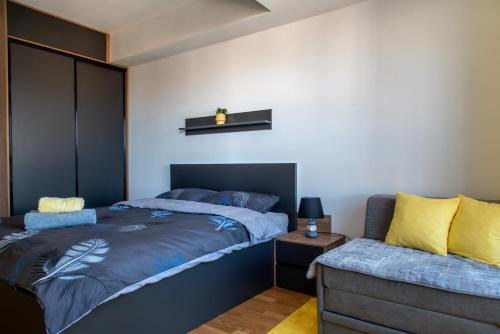 斯科普里Exclusive & Modern Apartment的一间卧室配有一张床和一张沙发