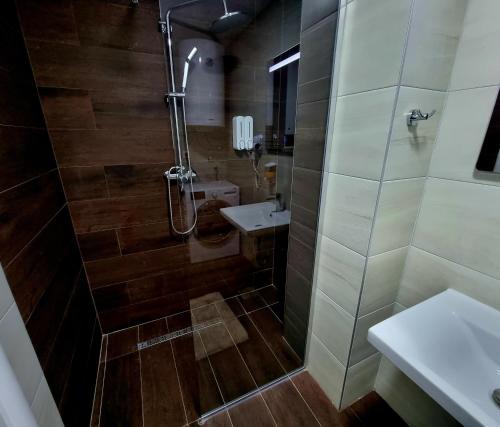 斯科普里Exclusive & Modern Apartment的带淋浴、卫生间和盥洗盆的浴室
