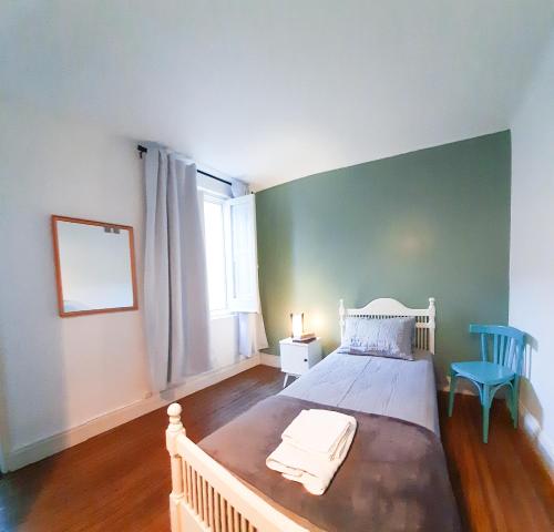 布宜诺斯艾利斯LOPEZ Hostel & Suites的卧室配有白色的床和蓝色椅子