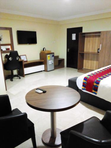 塔科拉迪RHOGEM Hotel的酒店客房配有一张床和一张茶几