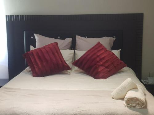 彼得马里茨堡Fabulous guest house的床上有两个红色枕头的床