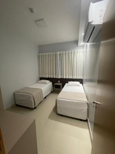 卡达斯诺瓦斯Lagoa EcoTowers Resort Hotel的小型客房 - 带2张床和窗户