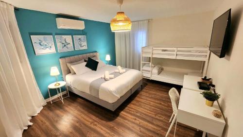 埃拉特VILLA SHUNIT- וילה שונית by barak royal suites的卧室配有白色的床和蓝色的墙壁