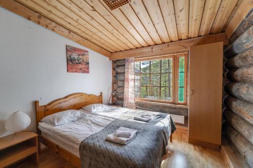 普哈圣山Log Villa Tietotunturi的一间卧室设有一张床和一个大窗户