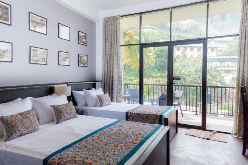 康提Kandy City View的一间卧室设有两张床和大窗户