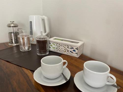 门多萨Gomez Point Mendoza的桌子上两杯和碟子,配有咖啡壶