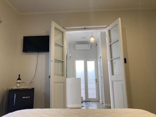门多萨Gomez Point Mendoza的一间卧室设有一扇门,可通往一个配有电视的房间