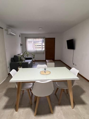 图努扬Departamento 2 habitaciones planta baja Hasta 4 huéspedes的客厅配有白色的桌子和椅子