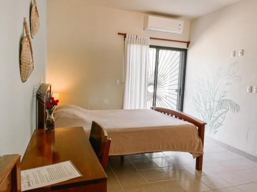 托拉Mar Adentro Sanctuary的一间卧室配有一张床、一张桌子和一个窗户。
