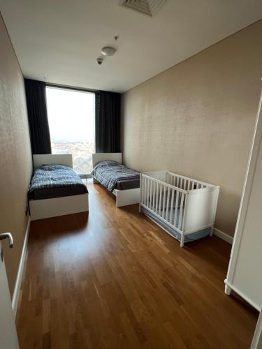伊斯坦布尔Skyland的一间卧室配有两张床和一张婴儿床。