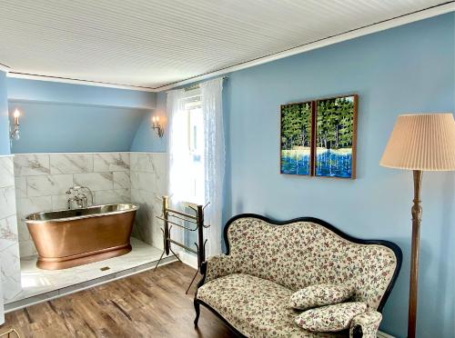 奥卡斯奥卡斯酒店的带浴缸、椅子和水槽的浴室