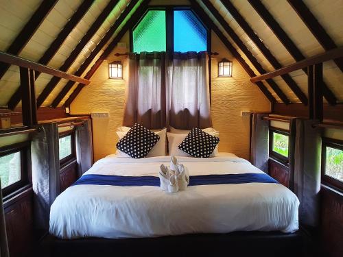 卡农Baan Thong Ching Resort的一间卧室设有一张大床和窗户