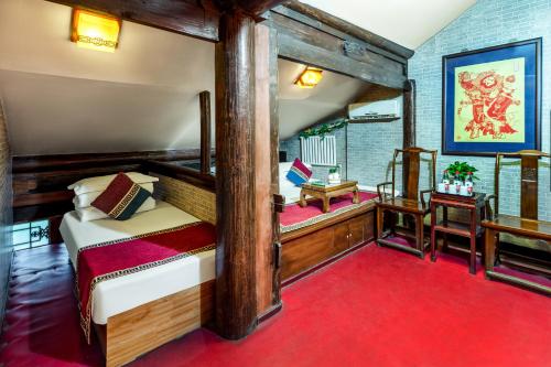 平遥平遥百常宏客栈的一间卧室配有一张床,铺有红色地毯