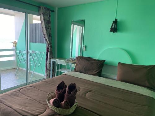 格兰岛วินเนอร์วิว เกาะล้าน的一间拥有绿色墙壁的卧室和一张带鞋的床