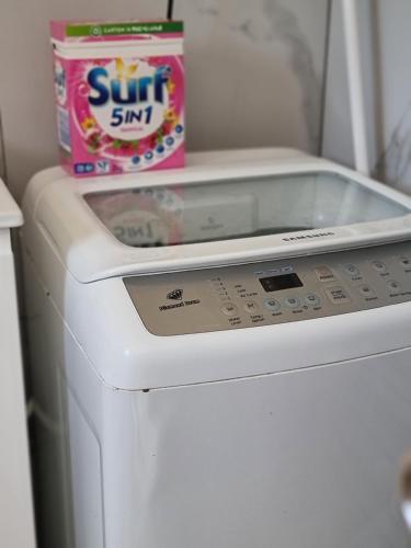 洛甘利The Lux Guest House的洗衣机和烘干机,配有一盒太阳芯片