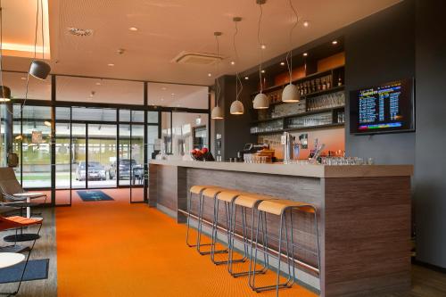 莱比锡Campanile Leipzig Halle Airport的餐厅设有铺有橙色地毯的酒吧