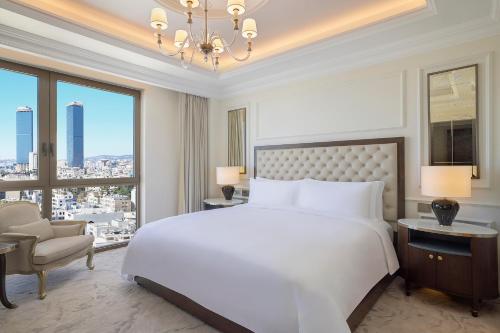 安曼The Ritz-Carlton, Amman的卧室设有一张白色大床和大窗户
