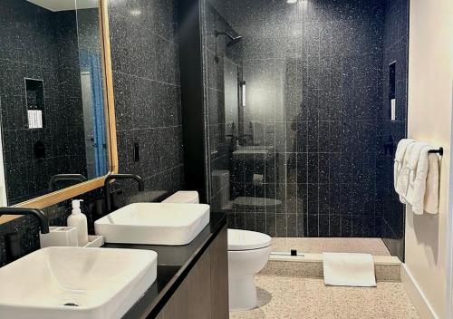 奥斯汀Brand New - Spacious Luxury Condo, Steps from Lake & Rainey for 4的一间带水槽、卫生间和淋浴的浴室