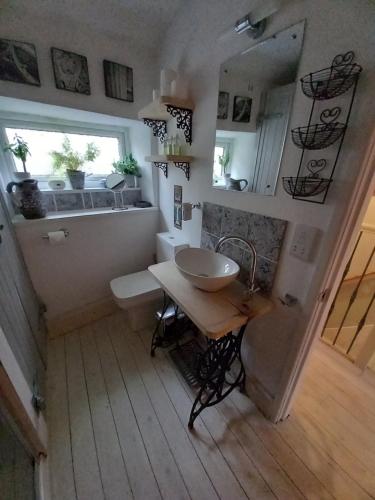 斯基普顿Little Pinfold Cottage的一间带水槽、桌子和窗户的浴室