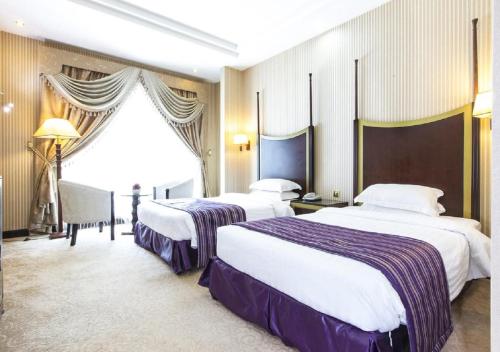 多哈旅客酒店的酒店客房设有两张床和窗户。