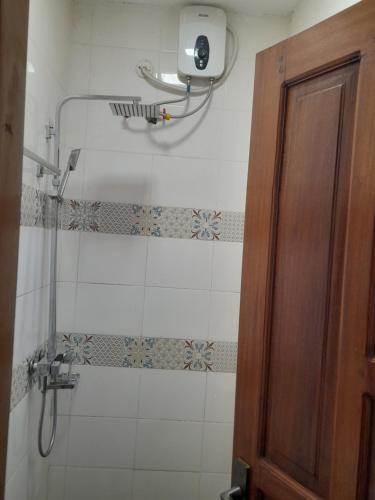 坎帕拉Ella Apartment Albert Cook Road的带淋浴的浴室和玻璃门