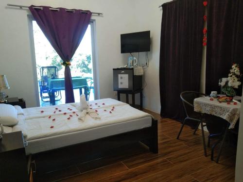BolinaoCouple room in Final Destination Resort的一间卧室,床上铺有红色玫瑰花瓣