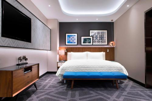 吉隆坡Le Méridien Kuala Lumpur的一间卧室配有一张大床和一台平面电视
