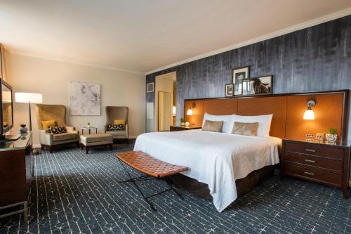 休斯顿休斯顿白玉兰酒店 - 翠贡精选酒店的酒店客房带一张大床和一把椅子