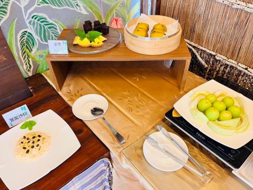 鹅銮鼻垦丁盘古拉渡假花园民宿的一张桌子,上面放着两盘水果